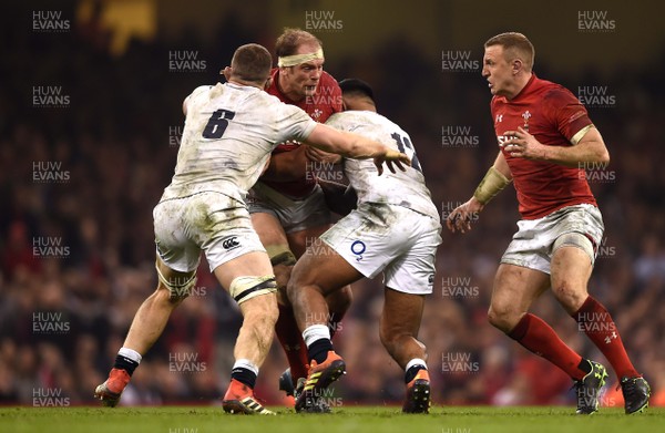 230219 - Wales v England - Guinness Six Nations - Alun Wyn Jones of Wales is tackled by Mark Wilson and Manu Tuilagi of England