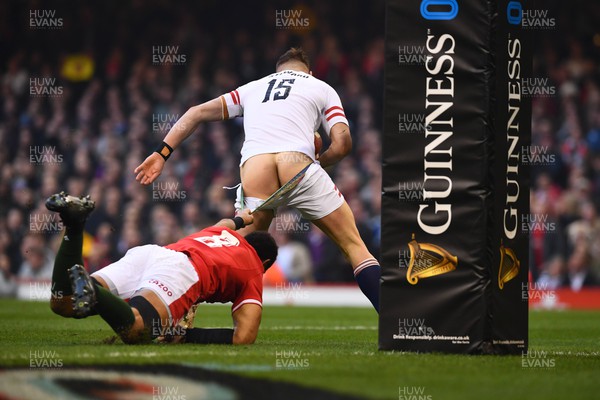 250223 - Wales v England - Guinness Six Nations 2023 - Freddie Steward of England is tackled by Taulupe Faletau of Wales