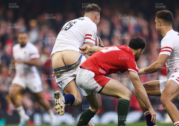 250223 - Wales v England, Guinness Six Nations 2023 - Freddie Steward of England has his shorts pulled down as he escapes from Taulupe Faletau of Wales