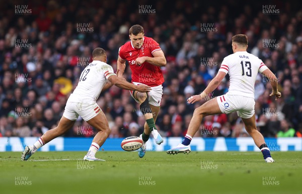 250223 - Wales v England, Guinness Six Nations 2023 - Mason Grady of Wales kicks between Ollie Lawrence of England and Henry Slade of England