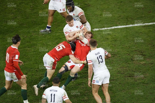 250223 - Wales v England - Guinness Six Nations - Nick Tompkins of Wales is held up by Owen Farrell of England