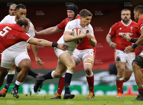 270221 - Wales v England - Guinness 6 Nations - Owen Farrell of England is tackled by Alun Wyn Jones and Adam Beard of Wales