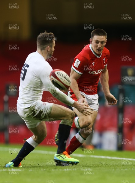 270221 - Wales v England, Guinness 2021 Six Nations Championship - Josh Adams of Wales kicks past Elliot Daly of England