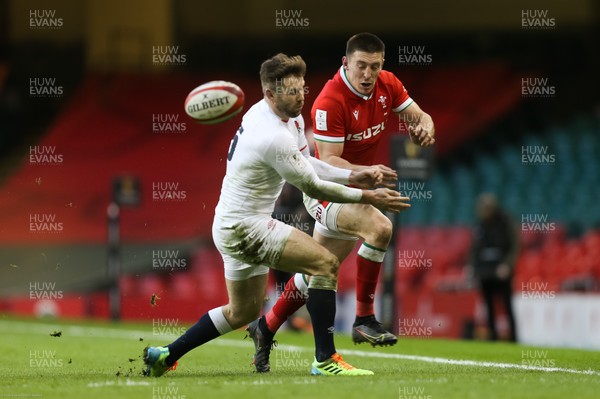 270221 - Wales v England, Guinness 2021 Six Nations Championship - Josh Adams of Wales kicks past Elliot Daly of England
