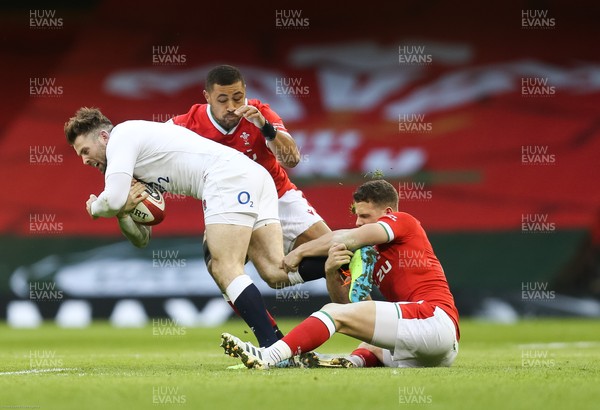 270221 - Wales v England, Guinness 2021 Six Nations Championship - Elliot Daly of England is tackled by Kieran Hardy of Wales and Taulupe Faletau of Wales