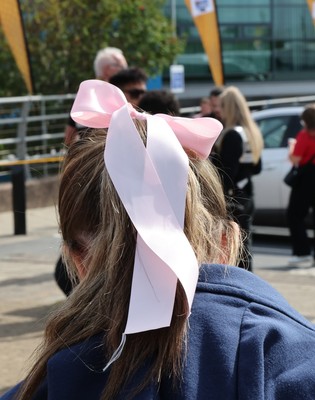 060925 - Wales v Fiji, Women’s Rugby World Cup - Wales fans sport pink bows as they wait for the team to arrive at the stadium ahead of the match