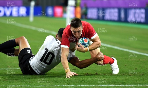 091019 - Wales v Fiji - Rugby World Cup - Josh Adams of Wales is tackled by Ben Volavola of Fiji
