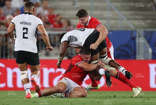 100923 - Wales v Fiji - Rugby World Cup 2023 - Pool C - Viliame Mata of Fiji is tackled by Gareth Thomas and Will Rowlands of Wales 