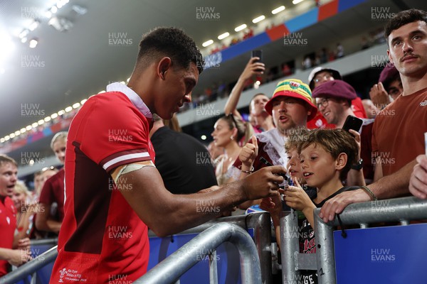 100923 - Wales v Fiji - Rugby World Cup 2023 - Pool C - Rio Dyer of Wales signs autographs at full time