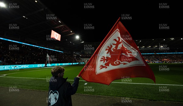 210324 - Wales v Finland, Euro 2024 qualifying play-off semi-final - A flag bearer waves a flag as the team enter the stadium