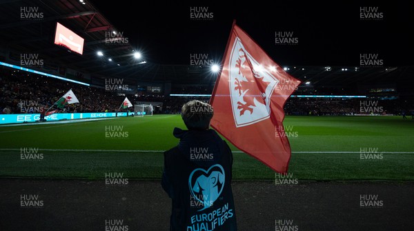 210324 - Wales v Finland, Euro 2024 qualifying play-off semi-final - A flag bearer waves a flag as the team enter the stadium