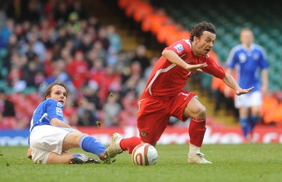 28.03.09 - Wales v Finland, FIFA World Cup 2010 Qualifying Group 4 -  Wales' Simon Davies is brought down by a tackle from Finland's Markus Heikkinen 