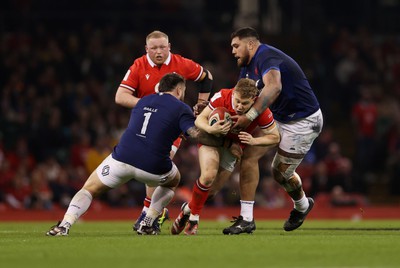 100324 - Wales v France - Guinness 6 Nations Championship - Sam Costelow of Wales is tackled by Cyril Baille and Emmanuel Meafou of France 