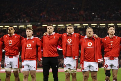 100324 - Wales v France - Guinness 6 Nations Championship - Mackenzie Martin, Evan Lloyd, Mason Grady, Alex Mann, Corey Domachowski and Josh Adams of Wales sing the anthem