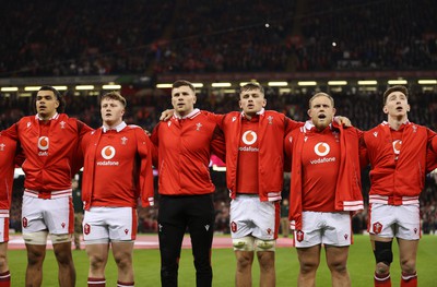 100324 - Wales v France - Guinness 6 Nations Championship - Mackenzie Martin, Evan Lloyd, Mason Grady, Alex Mann, Corey Domachowski and Josh Adams of Wales sing the anthem