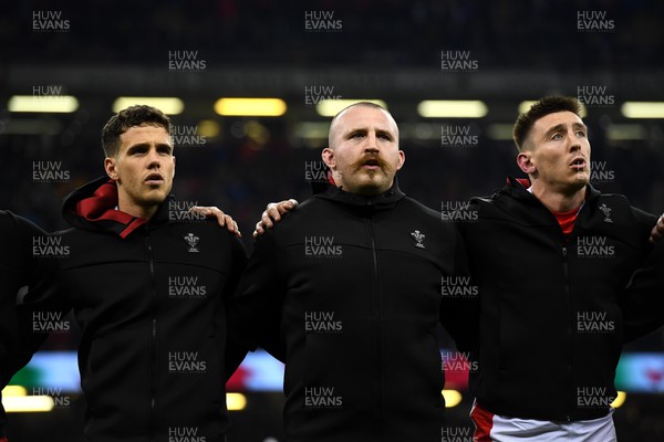 110322 - Wales v France - Guinness Six Nations - Kieran Hardy, Dillon Lewis and Josh Adams of Wales during the anthems