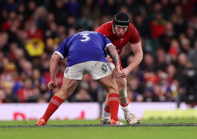 150226 - Wales v France - Guinness Six Nations Championship - Adam Beard of Wales is tackled by Dorian Aldegheri of France 