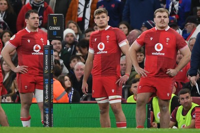 150226 - Wales v France - Guinness Men's Six Nations - A dejected Ryan Elias, Taine Plumtree and Archie Griffin of Wales look ahead after their side concedes a try