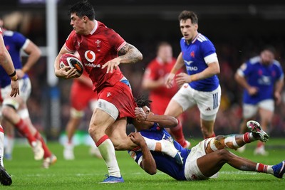 150226 - Wales v France - Guinness Men's Six Nations - Louis Rees-Zammit of Wales is challenged by Theo Attissogbe of France