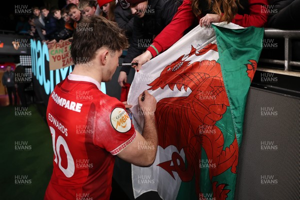 150226 - Wales v France - Guinness Six Nations Championship - Dan Edwards of Wales signs autographs at full time