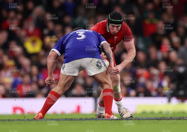 150226 - Wales v France - Guinness Six Nations Championship - Adam Beard of Wales is tackled by Dorian Aldegheri of France 