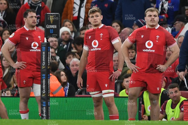 150226 - Wales v France - Guinness Men's Six Nations - A dejected Ryan Elias, Taine Plumtree and Archie Griffin of Wales look ahead after their side concedes a try