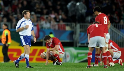 15.10.11 - Wales v France - Rugby World Cup Semi-Final 2011 - Referee Alain Rolland at the end of the game as Wales players look dejected. 