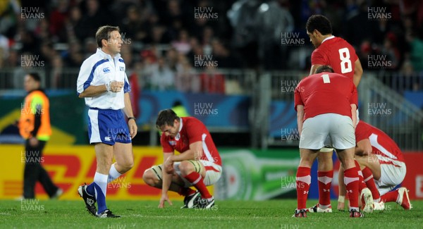 15.10.11 - Wales v France - Rugby World Cup Semi-Final 2011 - Referee Alain Rolland at the end of the game as Wales players look dejected. 