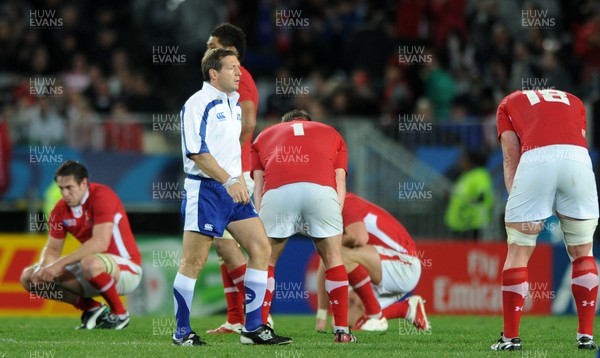 15.10.11 - Wales v France - Rugby World Cup Semi-Final 2011 - Referee Alain Rolland at the end of the game as Wales players look dejected. 