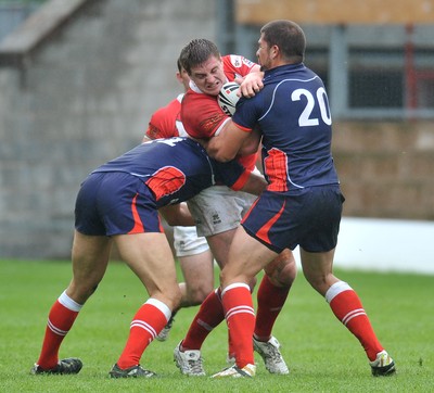 160612 - Wales v France  - Race Course Ground,  Wrexham - Jacob Emmitt of Wales, left, is tackled by Olivier Elima, left and Mickael Simon of France