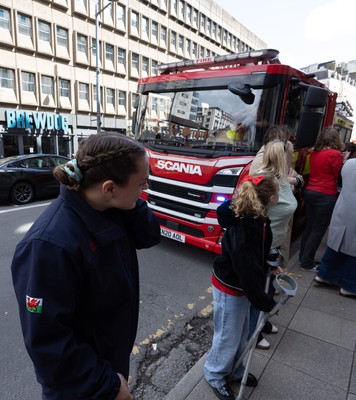 180426 - Wales v France, Guinness Women’s 6 Nations - Fire Fighter and Welsh International Jenni Scoble, who is on duty today rather than playing in the match, greets her team mates as they walk to the stadium