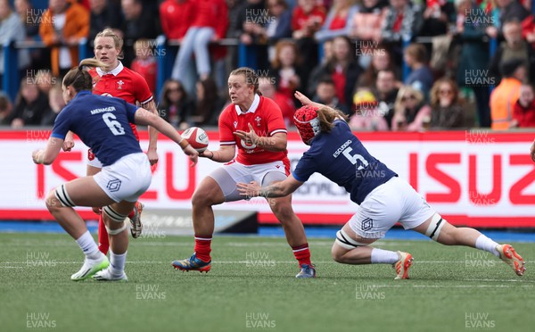 210424 - Wales v France, Guinness Women’s 6 Nations - Lleucu George of Wales feeds the ball out as Charlotte Escudero of France challenges