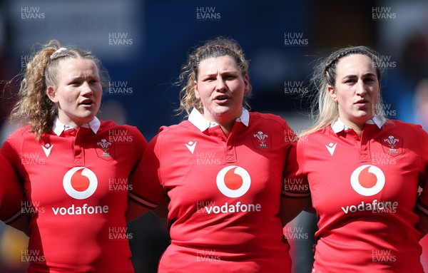 210424 - Wales v France, Guinness Women’s 6 Nations - Carys Cox of Wales and Gwenllian Pyrs of Wales and Courtney Keight of Wales line up for the anthems