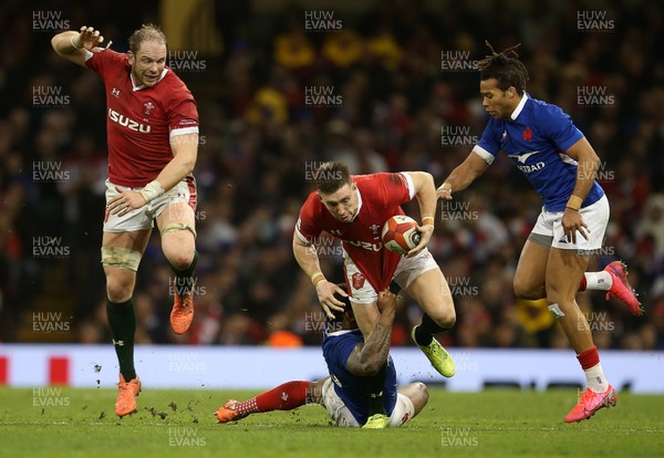 220220 - Wales v France - Guinness 6 Nations - Josh Adams of Wales is tackled by Virimi Vakatawa of France with Alun Wyn Jones jumping in the background