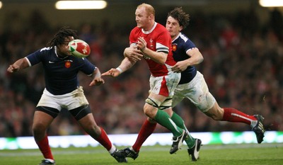 26.02.10 Wales v France... Wales' Martyn Williams passes under pressure from France's Mathieu Bastareaud and Julien Malzieu. 