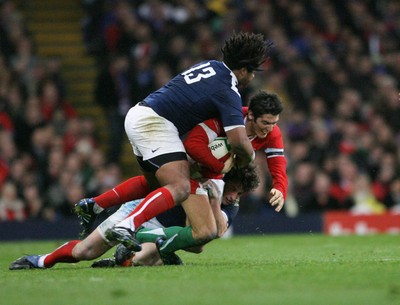 26.02.10 Wales v France... Wales' James Hook feels the force of France's Yannick Jauzion and Mathieu Bastareaud. 