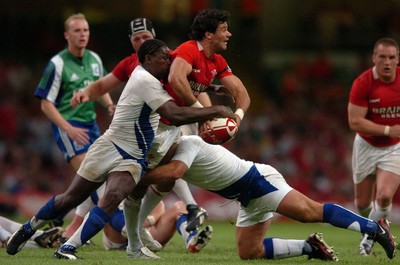26.08.07 - Wales v France - Invesco Perpetual 2007 Summer Series - Wales' Mike Phillips is tackled by France's Jean-Baptiste Paux and France's Serge Betsen(L) 