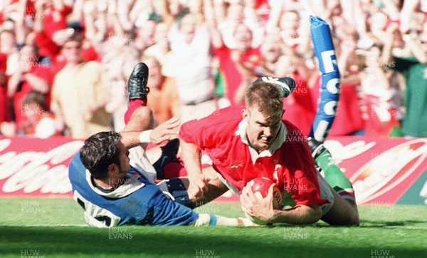 280899 - Wales 34 v 23 France - France Tour Match -  Dafydd James of Wales beats France's Xavier Garbajosa