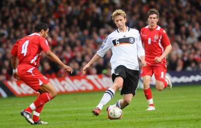 01.04.09 - Wales v Germany - World Cup 2010 - Qualifying Group 4 Germany's Simon Rolfes looks to get past Wales' Ashley Williams (L) as Aaron Ramsey looks on 