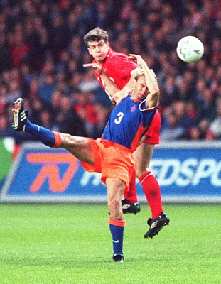 051096 - Wales v Holland - Mark Hughes of Wales climbs above Stan Valckx