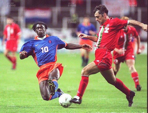 051096 - Wales v Holland - Mark Bowen of Wales is tackled by Clarence Seedorf