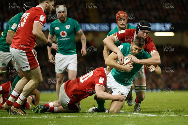 040223 - Wales v Ireland - Guinness Six Nations - Ross Byrne of Ireland is tackled by Adam Beard and Tommy Reffell of Wales