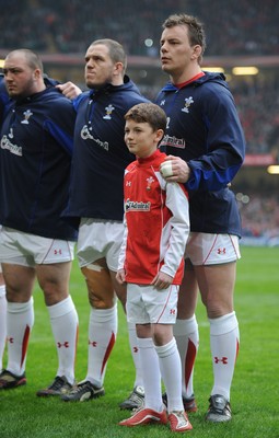 12.03.11 - Wales v Ireland - RBS Six Nations 2011 - Craig Mitchell, Paul James and Matthew Rees line-up for the national anthems with match mascot Tomas Rees. 