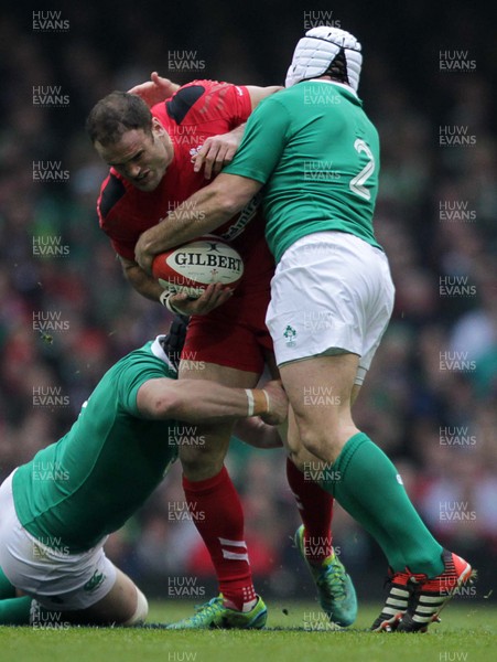 140315 - Wales v Ireland - RBS 6 Nations - Jamie Roberts of Walesis tackled by Sean OÕBrien and Rory Best of Ireland