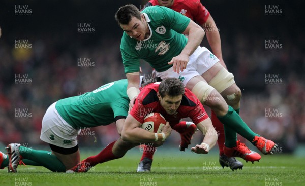 140315 - Wales v Ireland - RBS 6 Nations - Dan Biggar of Wales is tackled by Robbie Henshaw and Peter OÕMahony of Ireland