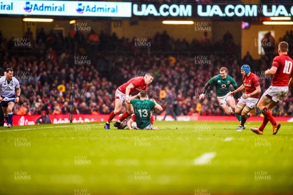 160319 - Wales v Ireland - Guinness Six Nations - Garry Ringrose of Ireland is tackled by Josh Adams and Aled Davies of Wales