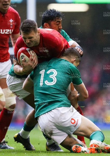 160319 - Wales v Ireland, Guinness Six Nations Championship 2019 - Dan Biggar of Wales is tackled by Bundee Aki of Ireland and Garry Ringrose of Ireland