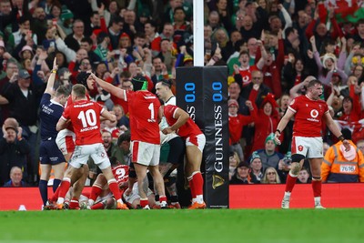 220225 - Wales v Ireland - Guinness Six Nations - Jac Morgan of Wales (obscured) scores his team's first try as his teammates celebrate