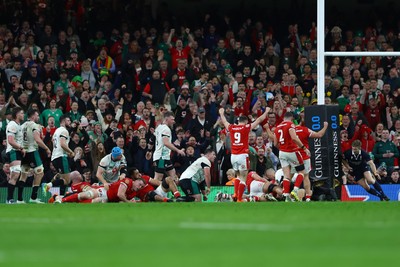 220225 - Wales v Ireland - Guinness Six Nations - Jac Morgan of Wales (obscured) scores his team's first try as his teammates celebrate