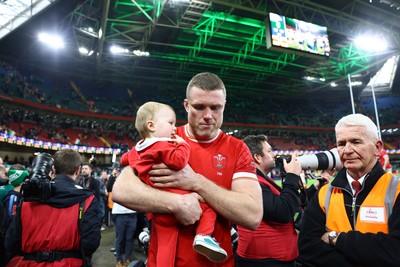 220225 - Wales v Ireland - Guinness Six Nations - Holding his child, Will Rowlands of Wales looks dejected after the match